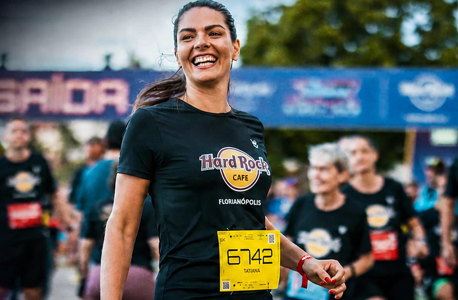 Atleta sorri na largada de uma edição anterior da Jurerê Night Run, com a camiseta do Hard Rock Cafe Florianópolis